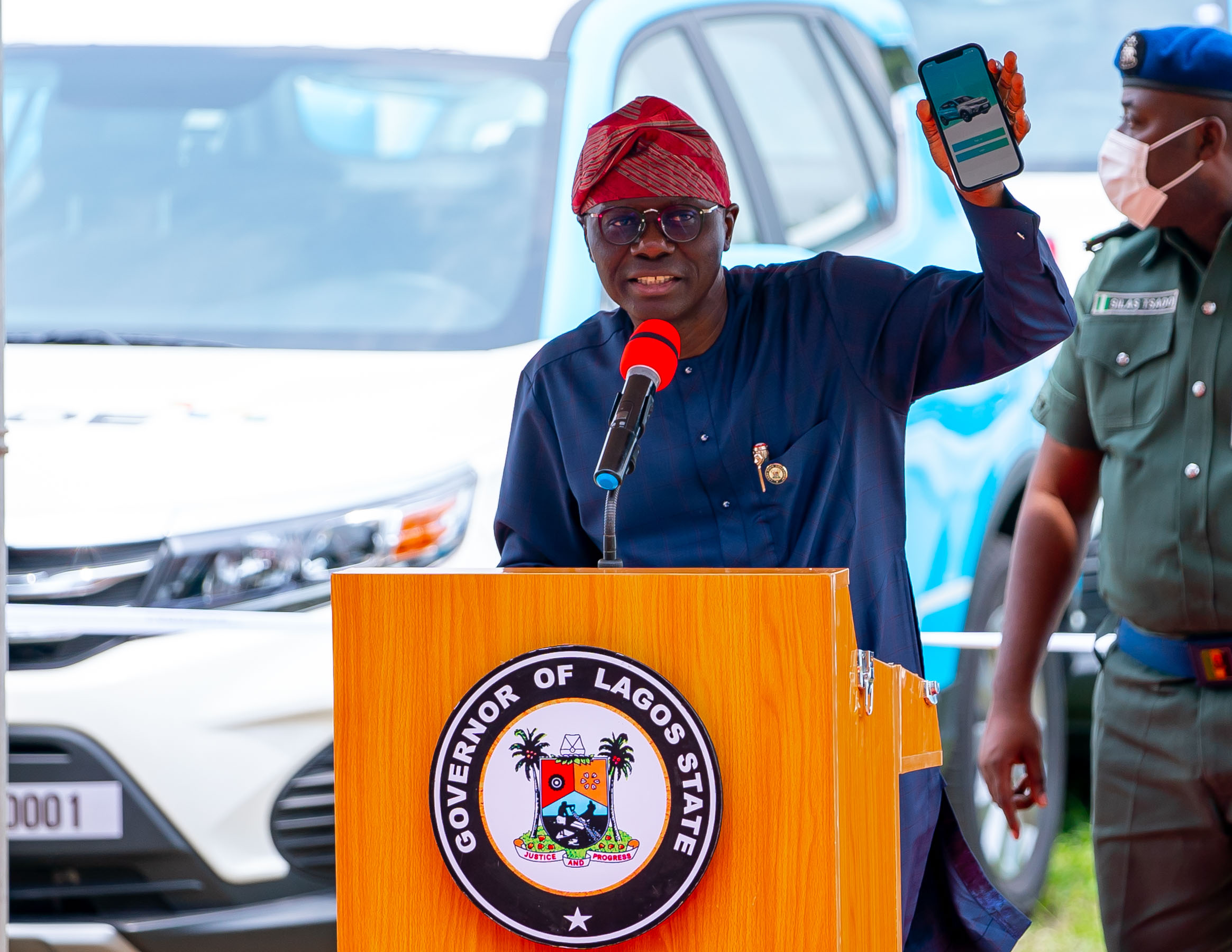 Lagos State Governor, Mr. Babajide Sanwo-Olu displays the LAGRIDE App on his handheld during the formal launch of 1000 Cars for Lagos Ride Taxi Scheme, at the Sports Ground, Lagos House, Alausa, Ikeja, on Monday, 23 March 2022.